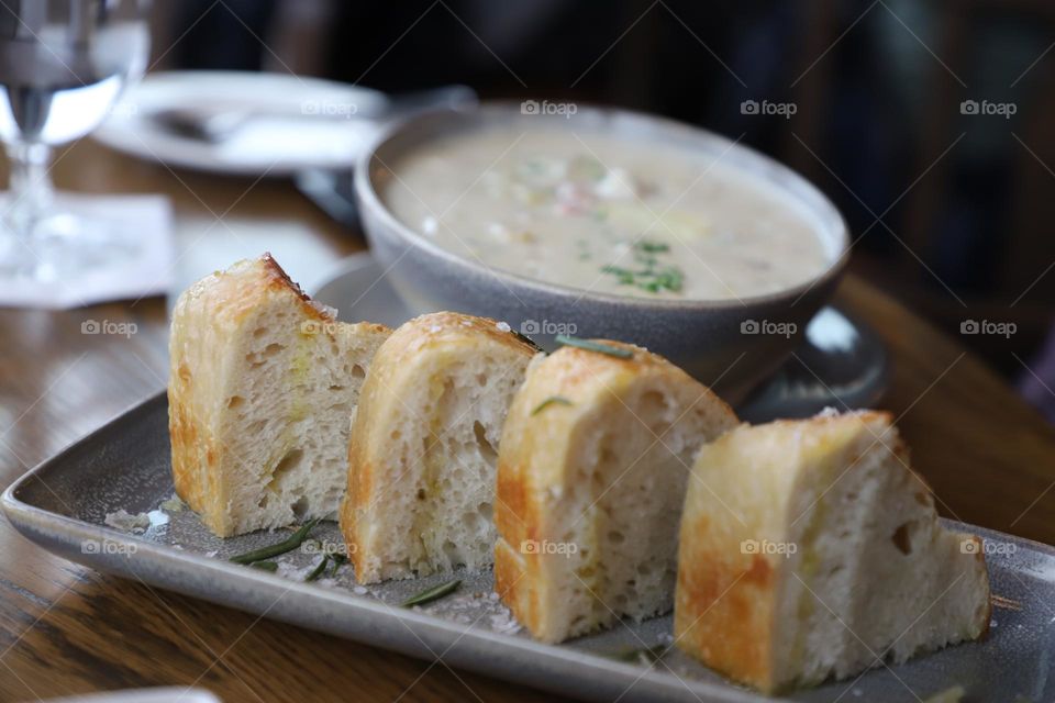 Fresh bread by a bowl of soup 