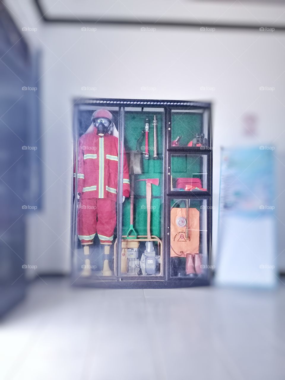 The glass cabinet contained various fire extinguihers