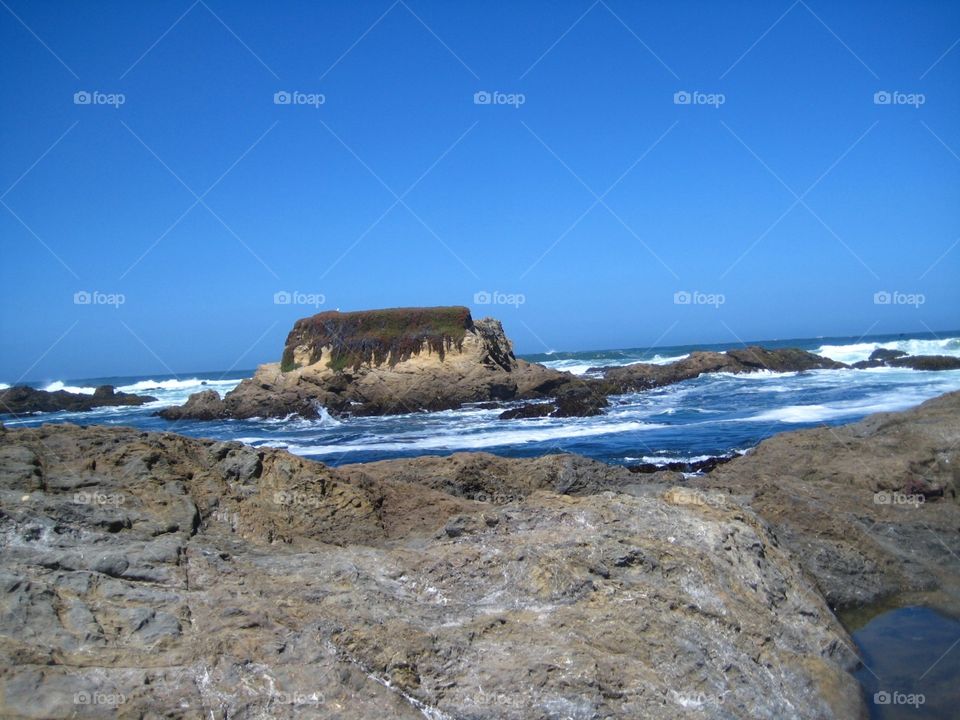 Rocky coast. Blue waters,  rocky coast and white surf