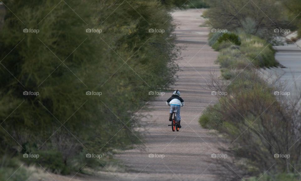 Little boy biking on the trail