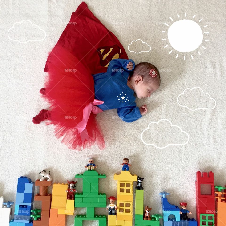 Baby girl sleeping on rug with toy