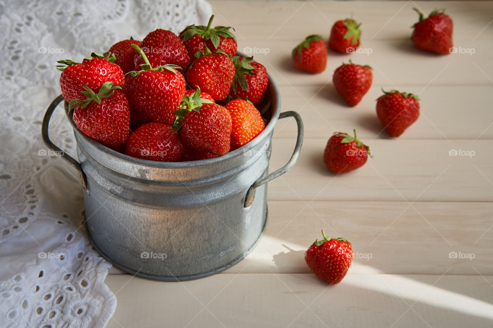 A metal vintage pail full of strawberries 