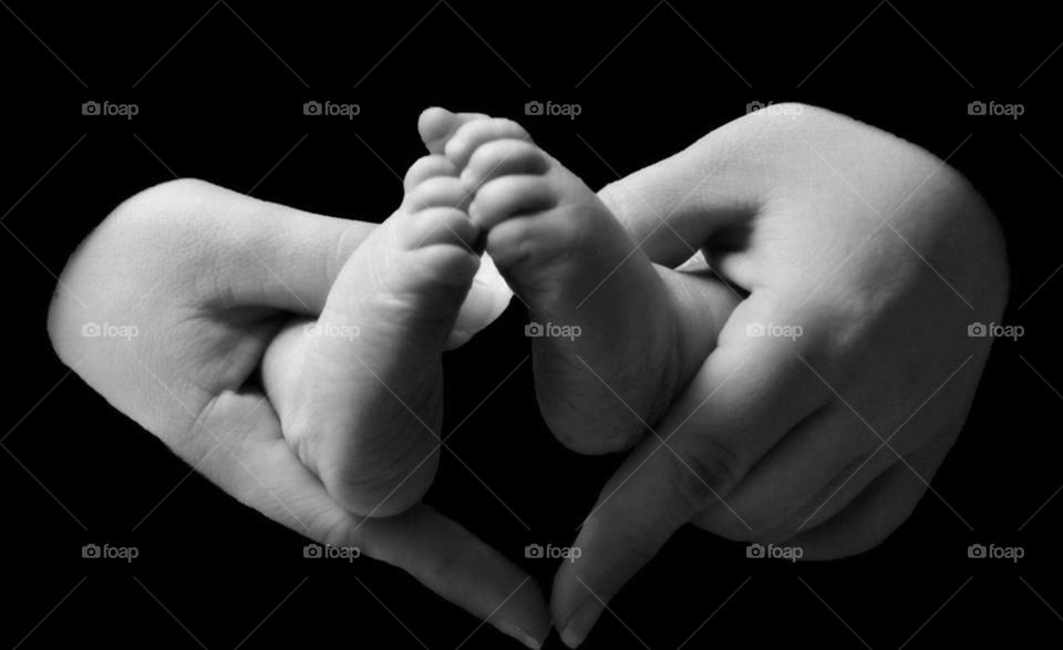 Baby feet. mama's hands cradle her newborn's feet