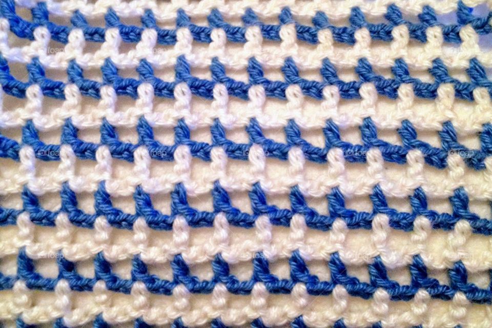 Close-up of handmade crocheted lacy blue and white stripped item