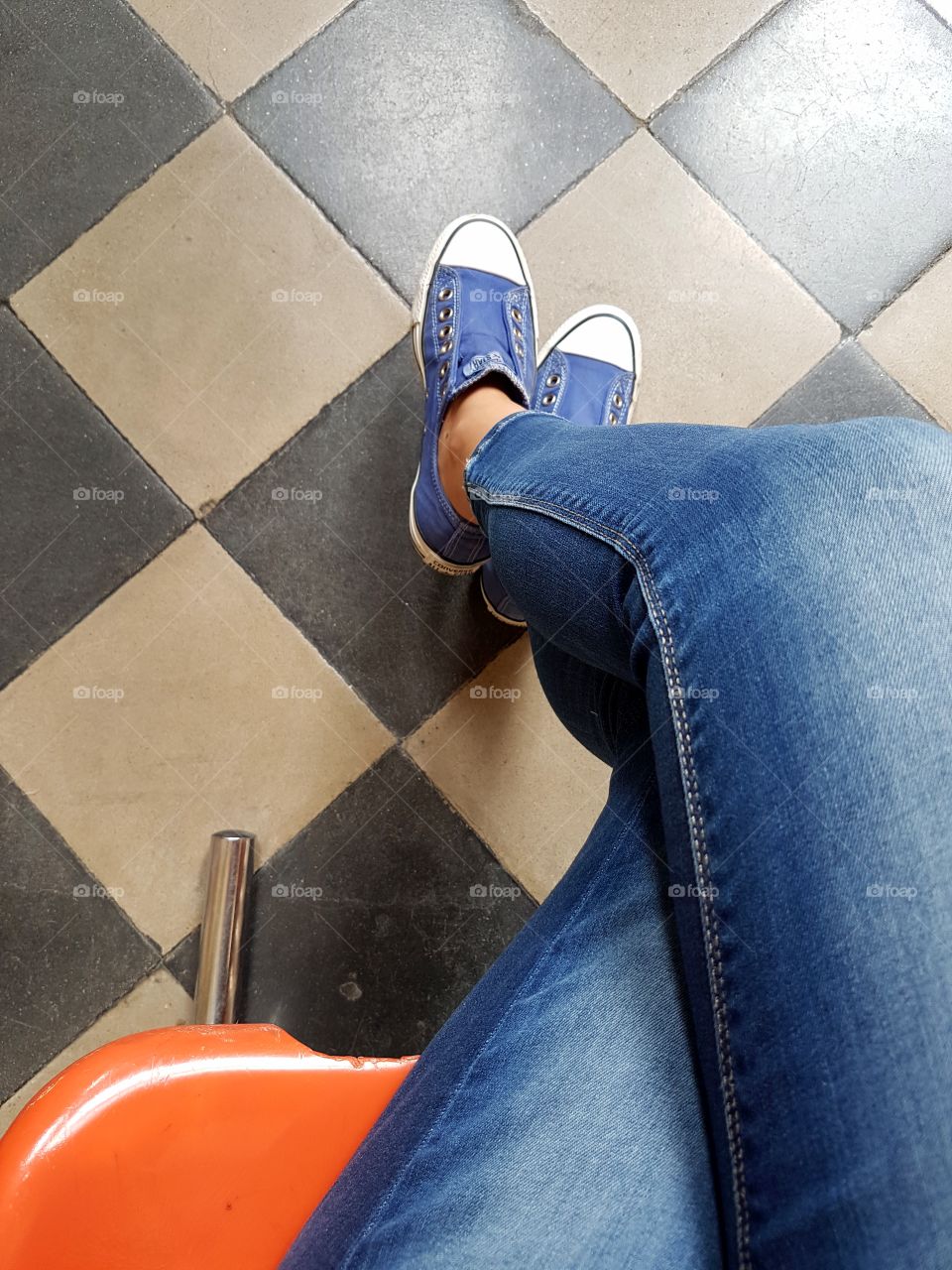 Woman legs with blue jeans and sneakers