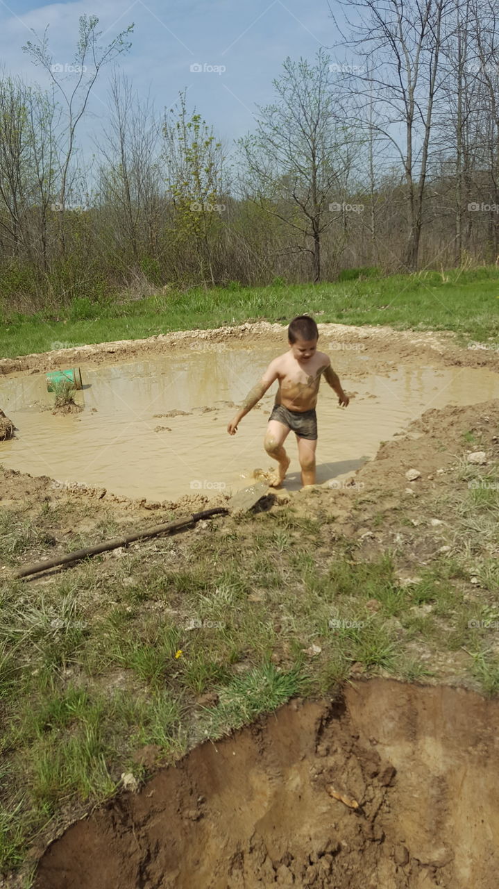 summer fun playing in a muddy puddle