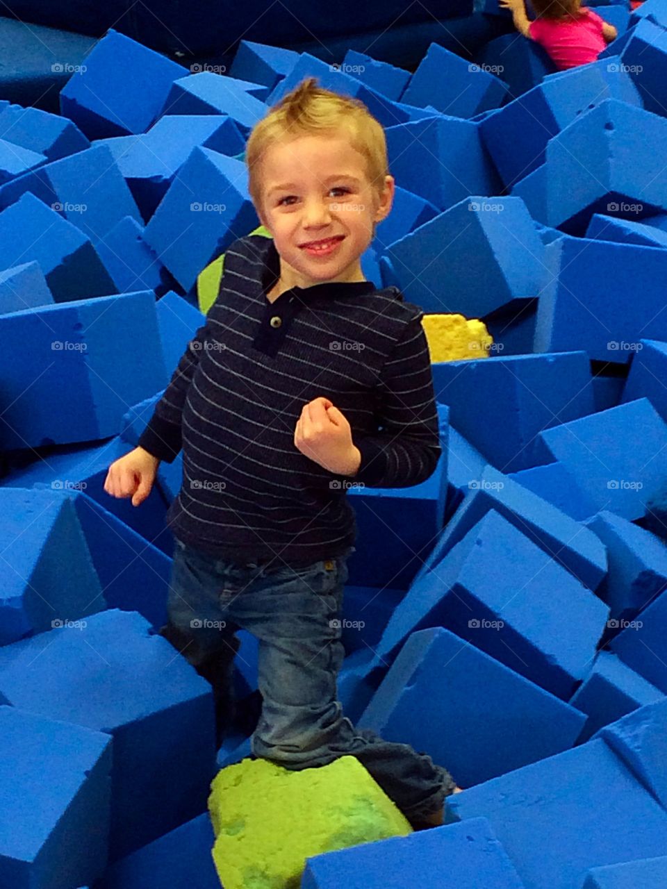 Yes I can . A boy proud of himself for jumping into a foam pit 