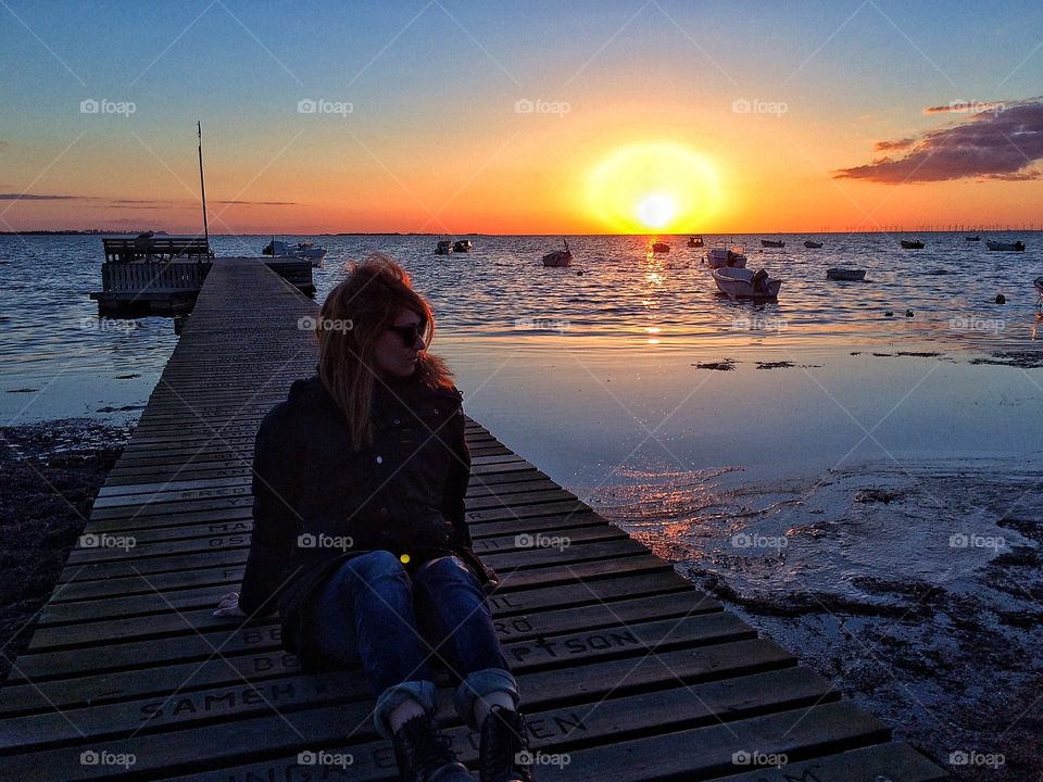 Girl on jetty in sunset
