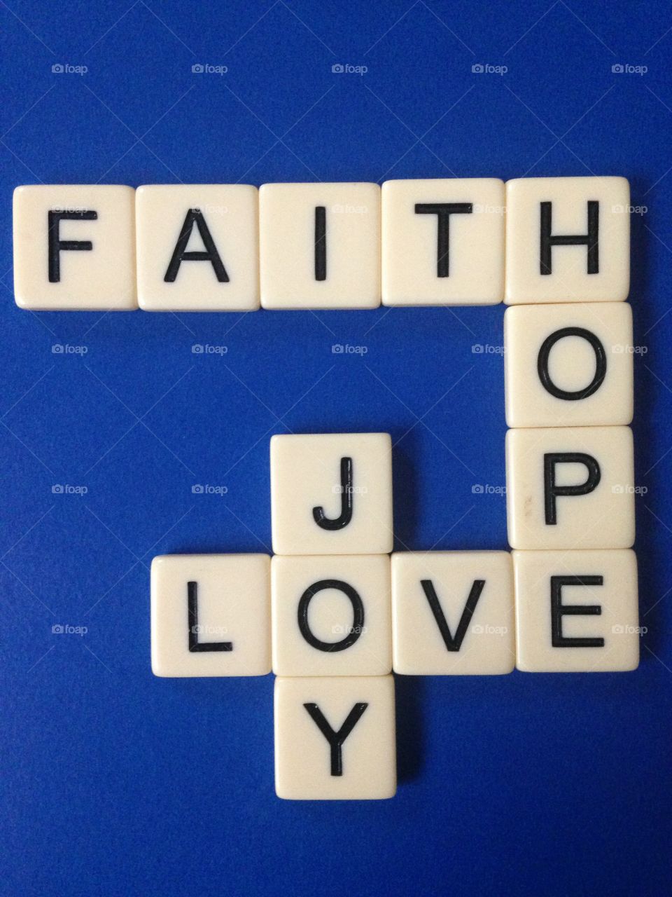 Faith, hope, love, and joy. Words made with letter tiles