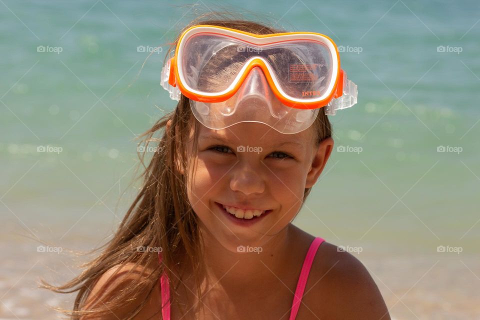 Portrait of caucasian child of 7-8 years in swimming mask looking at camera