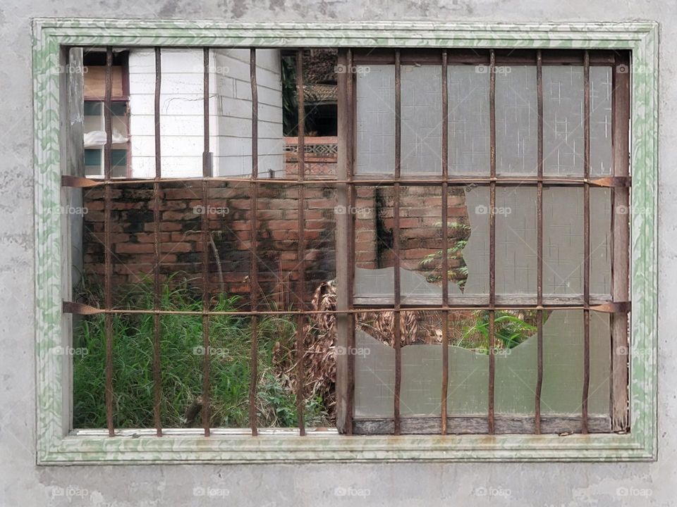 Broken window with red brick wall.