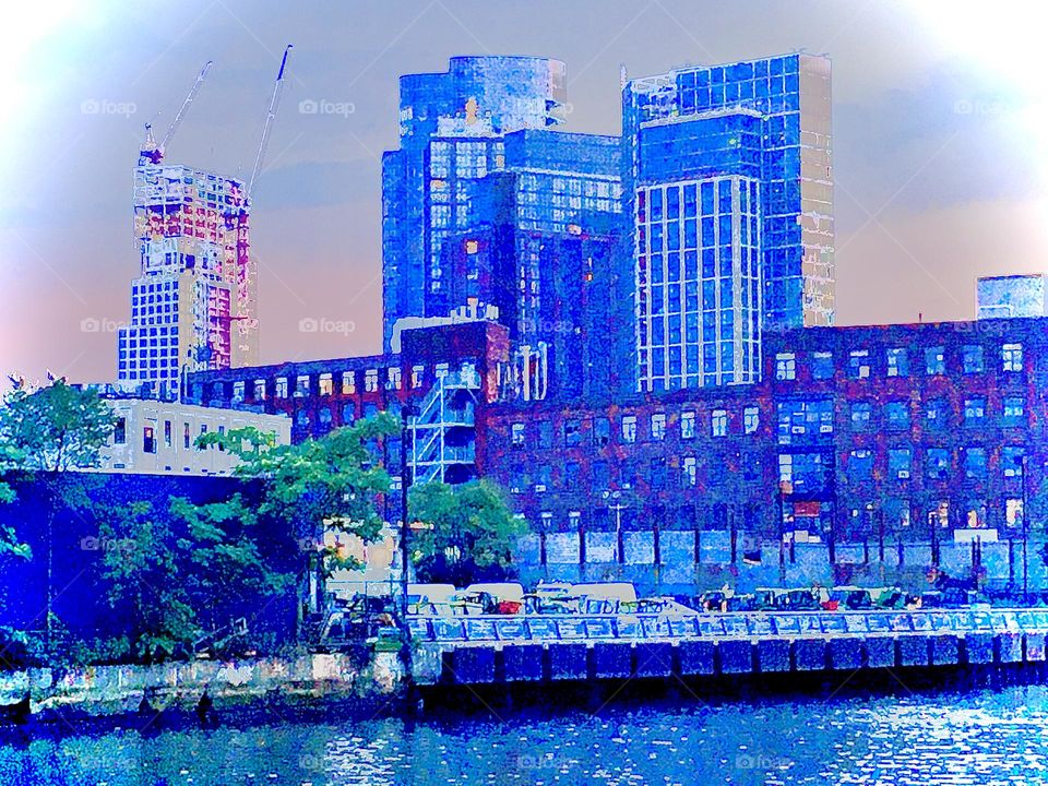 A closeup of the Greenpoint, Brooklyn side of the shore at Newtown Creek in Long Island City, Queens, NY at the twilight hour of upcoming nightfall with its bluish hues. 2019. Hypnotic Productions