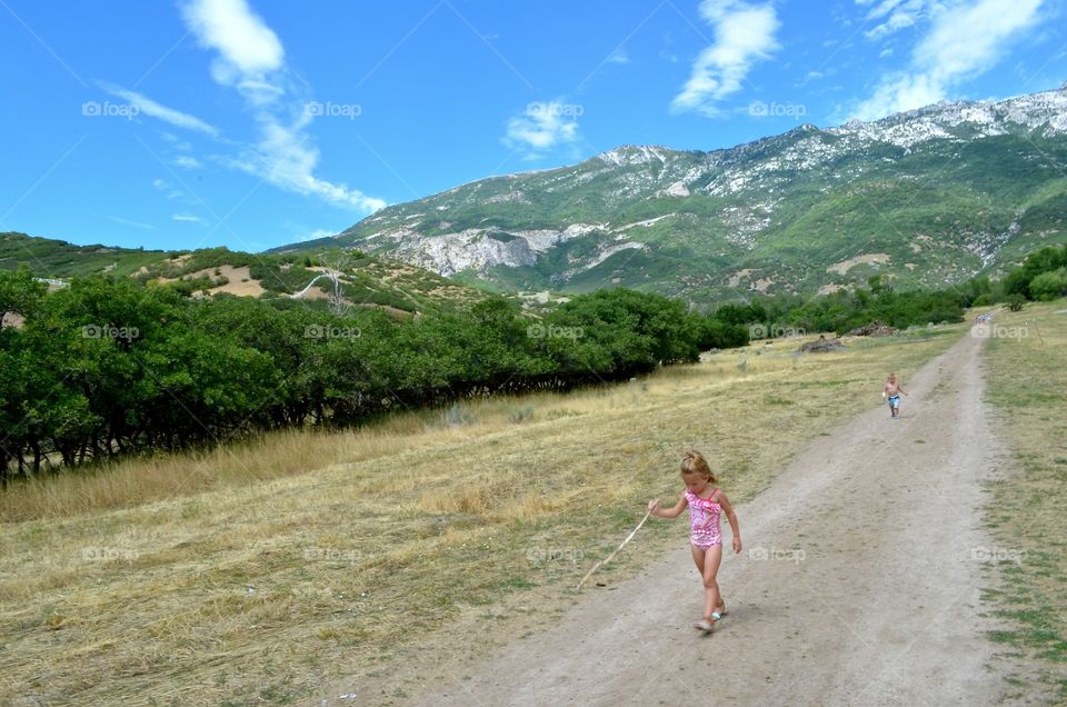 Adventure Seekers. Kids hiking, little girl hiking, little boy hiking, girl on trail, boy on trail, walking, walking stick, mountains, clouds, Utah, adventure, the great outdoors, Google, Foap, kids playing, kids outdoors,