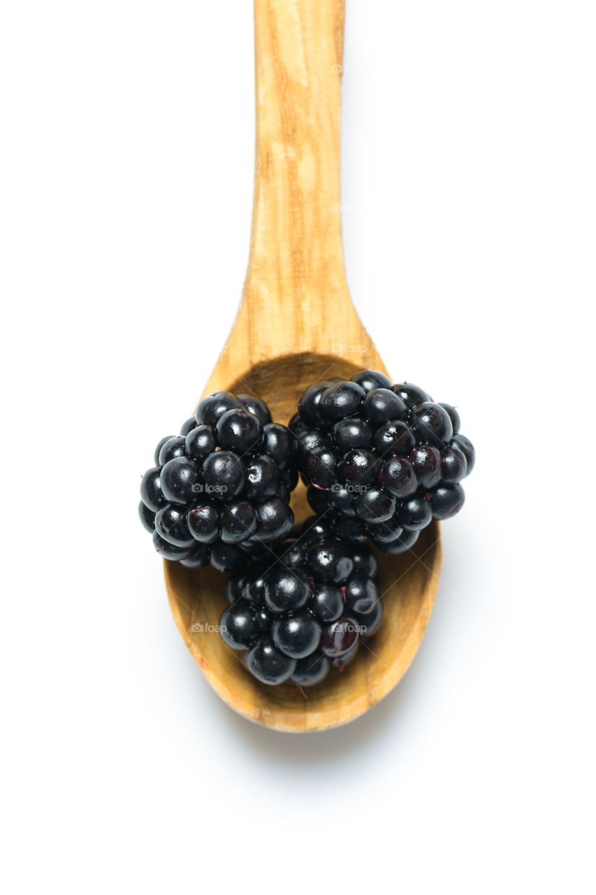 Wooden spoon of blackberries