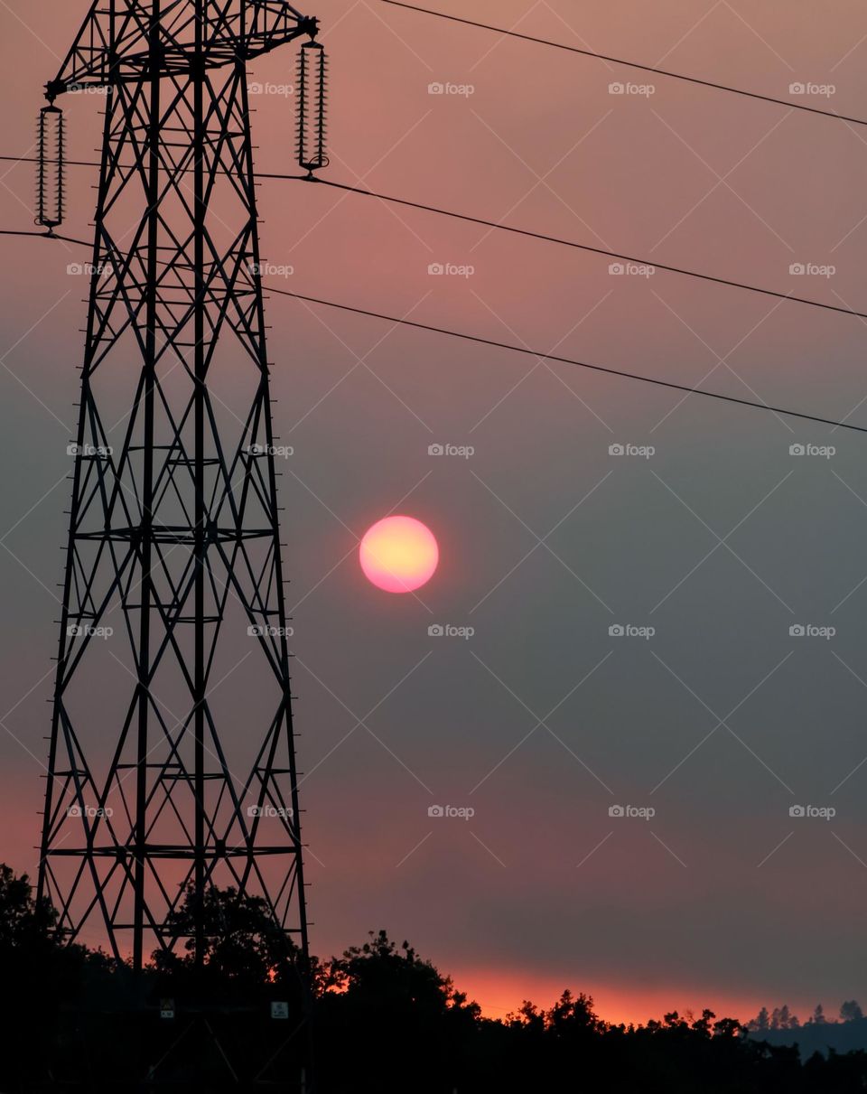 Sunset silhouettes tall metal pylons