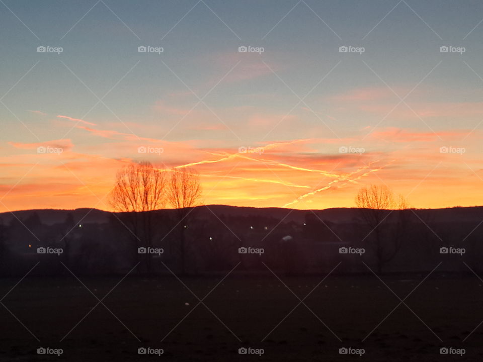 Sunset sky with airplane traces