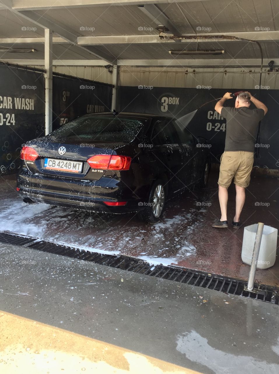 Man washes his car in a self-service car wash