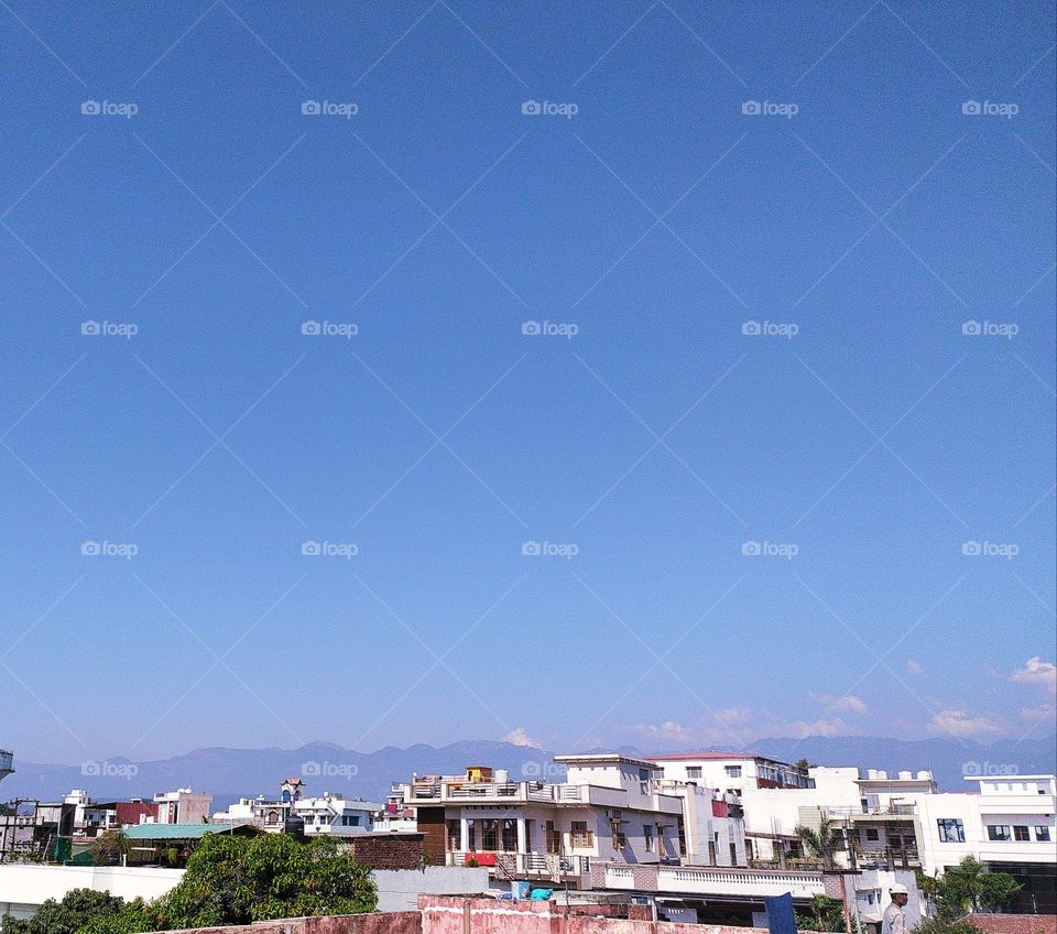 The beautiful Mussoorie hills and an exquisite blue sky providing a wonderful backdrop to the town of Dehradun, the City of Love