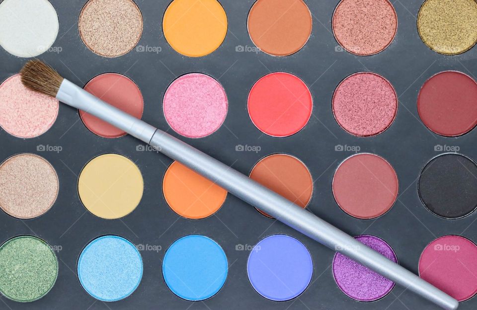 Makeup palette closeup with brush