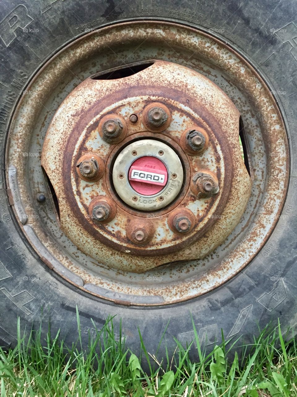 A truck tire with rusted wheel rim and bolts