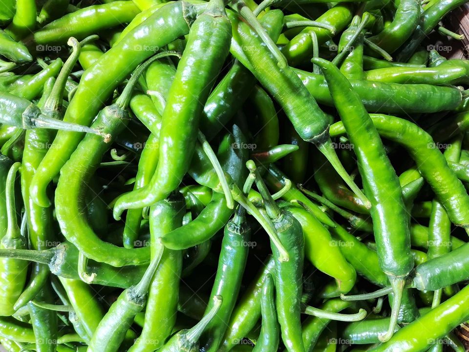 pile of fresh big green chilies in traditional market