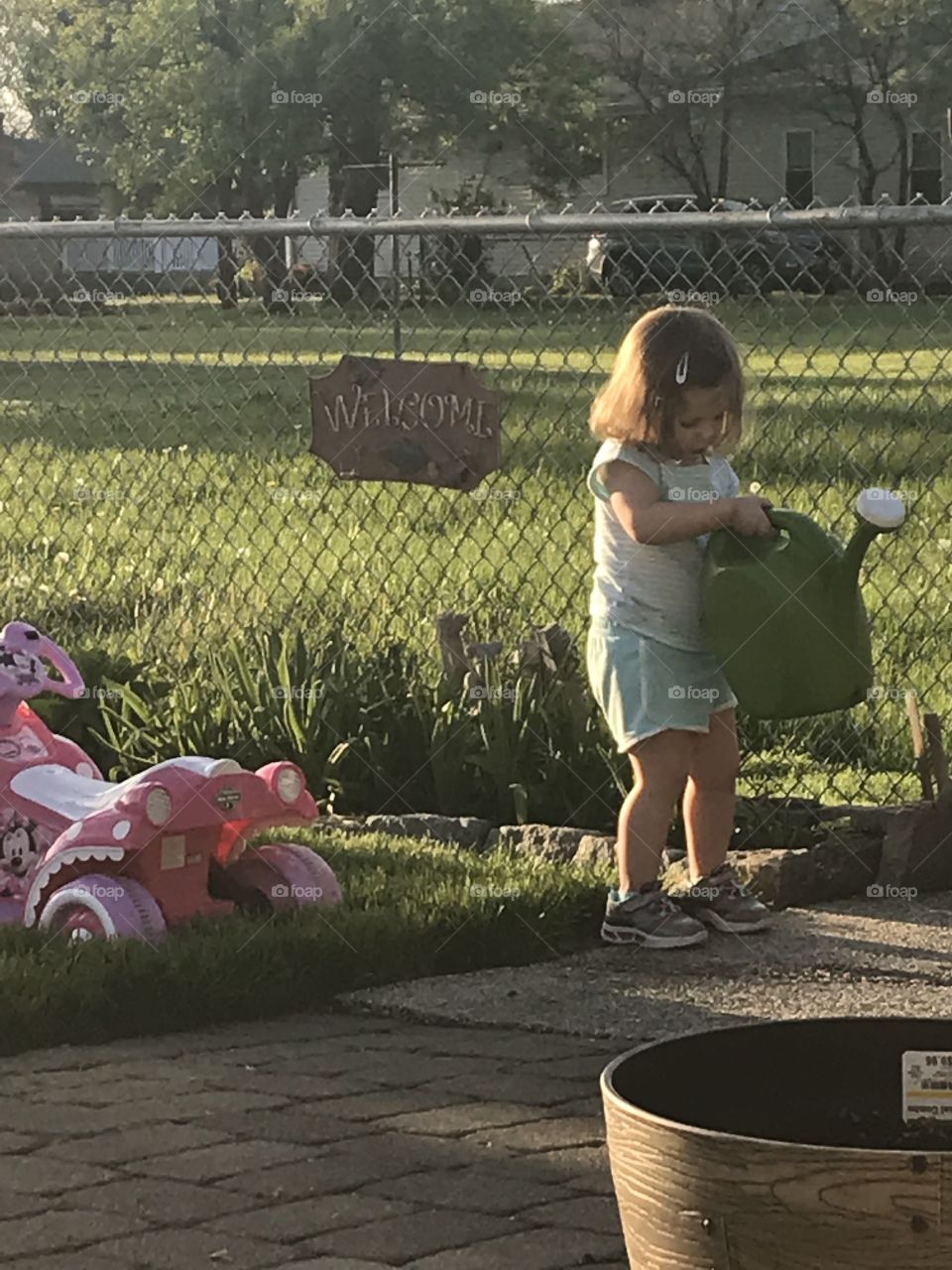 Playing with a watering can outside in the garden, making our flowers pretty! 