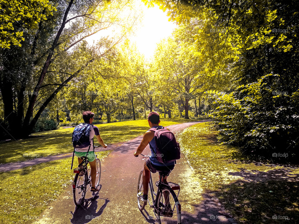 Two friends riding their bikes at a natural park in Bonn, Germany.