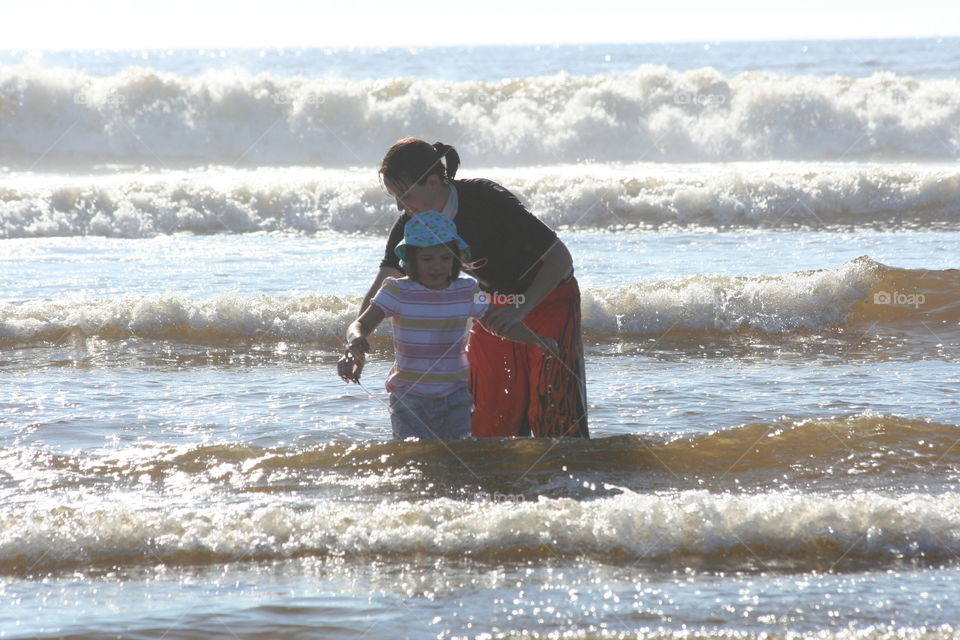 Mother and daughter in surf