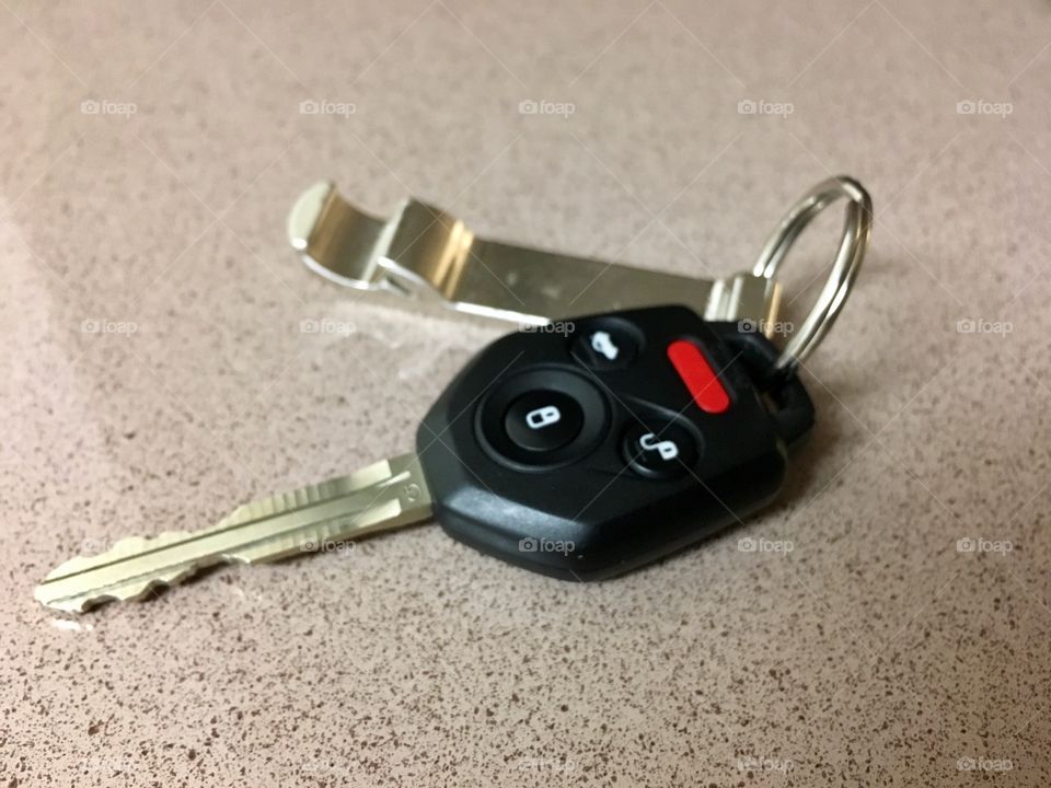 Car keys and bottle cap opener on Formica 