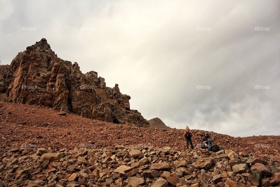 Dad and daughter rest on a halt in the mountains on a glacier