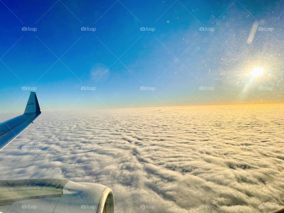 Captivating sunrise above the blanket of white clouds from airplane