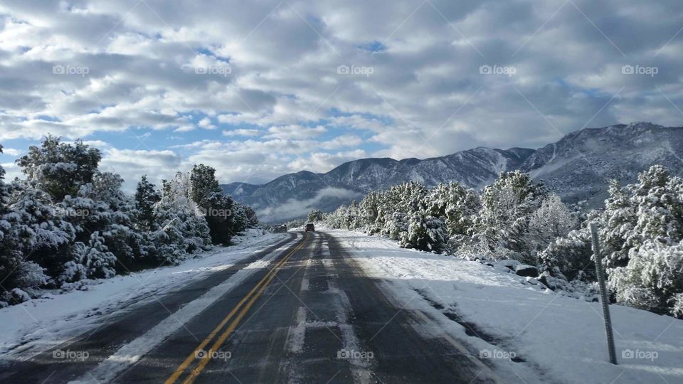 sky clouds mountain snow trees road