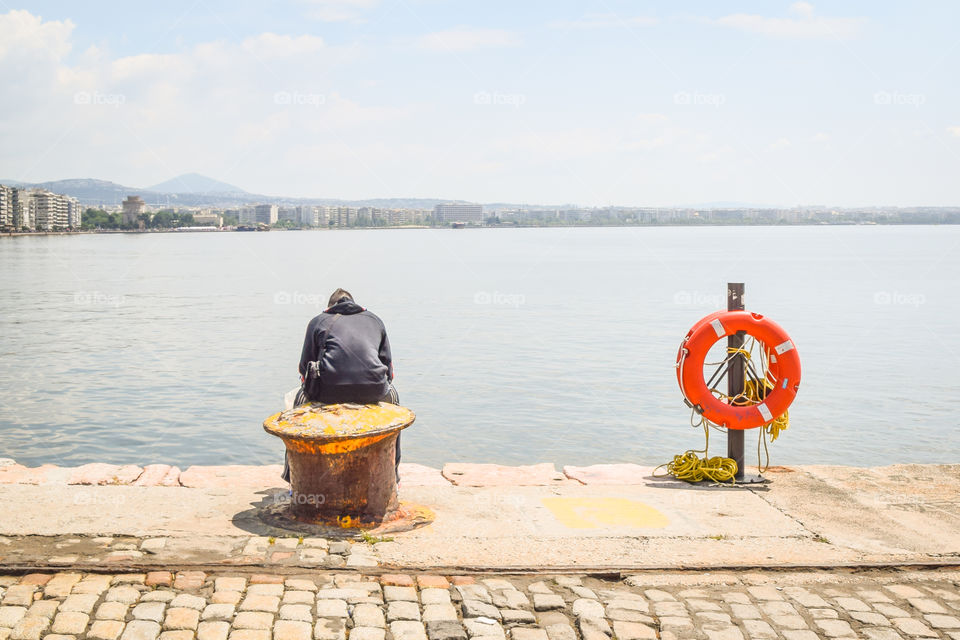 Young Man Sitting Alone At The Dock And Enjoying The View
