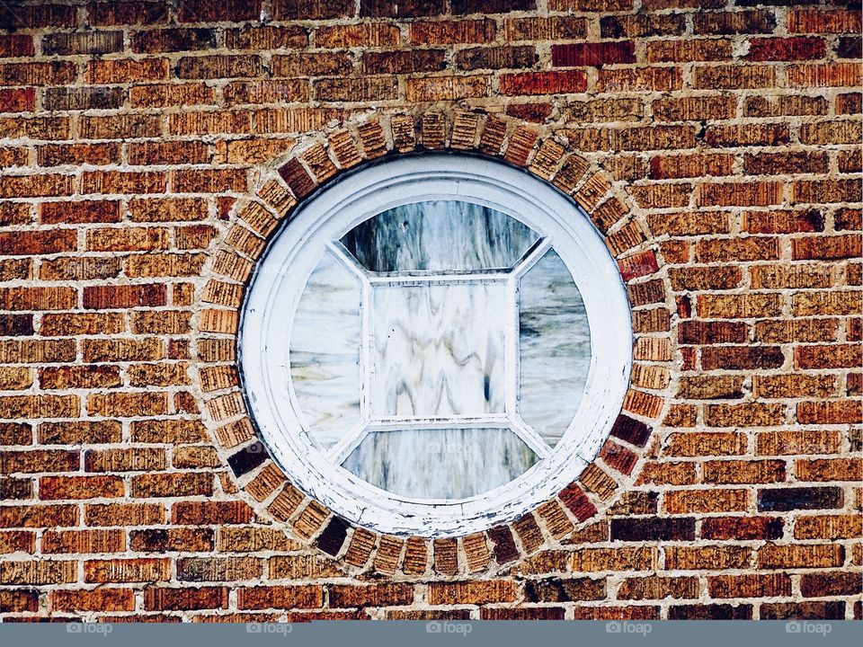 Stained glass circle portal in multi shades of brown brick