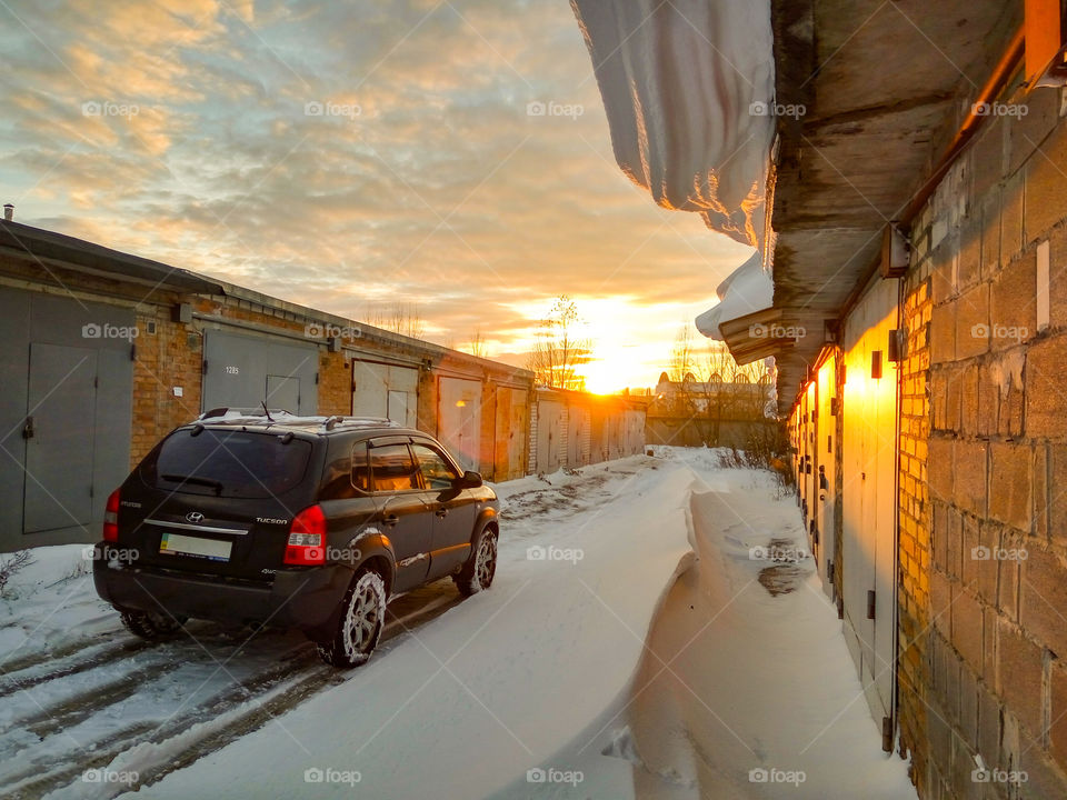 SUV at snowy sunset