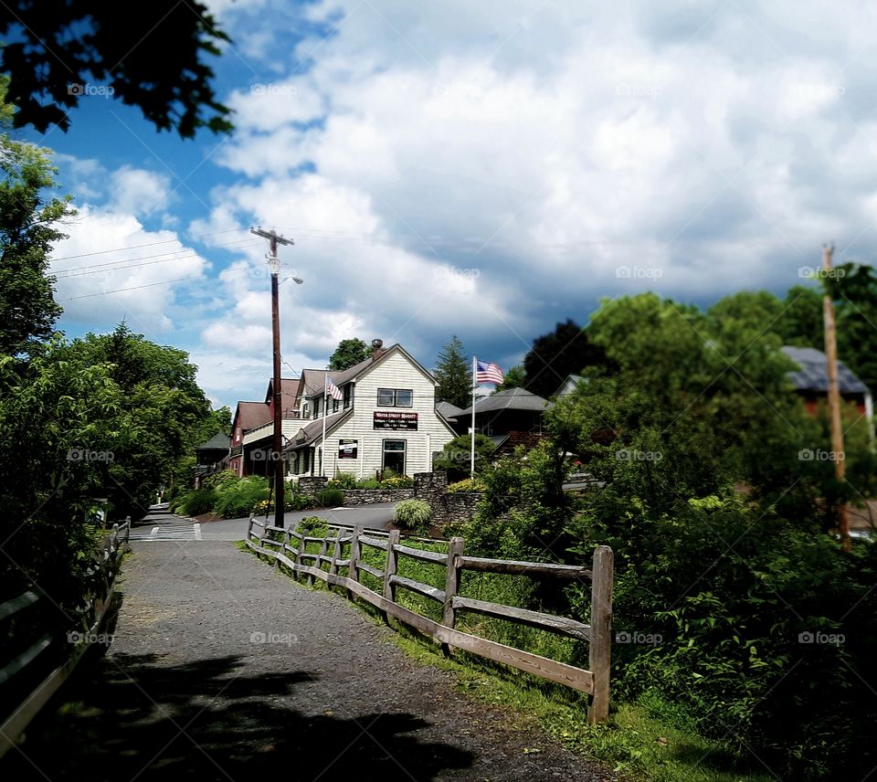 Pedestrian trail with fence and distant buildings