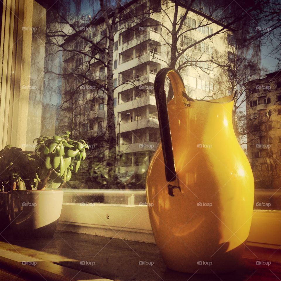 Yellow pitcher in sunny window
