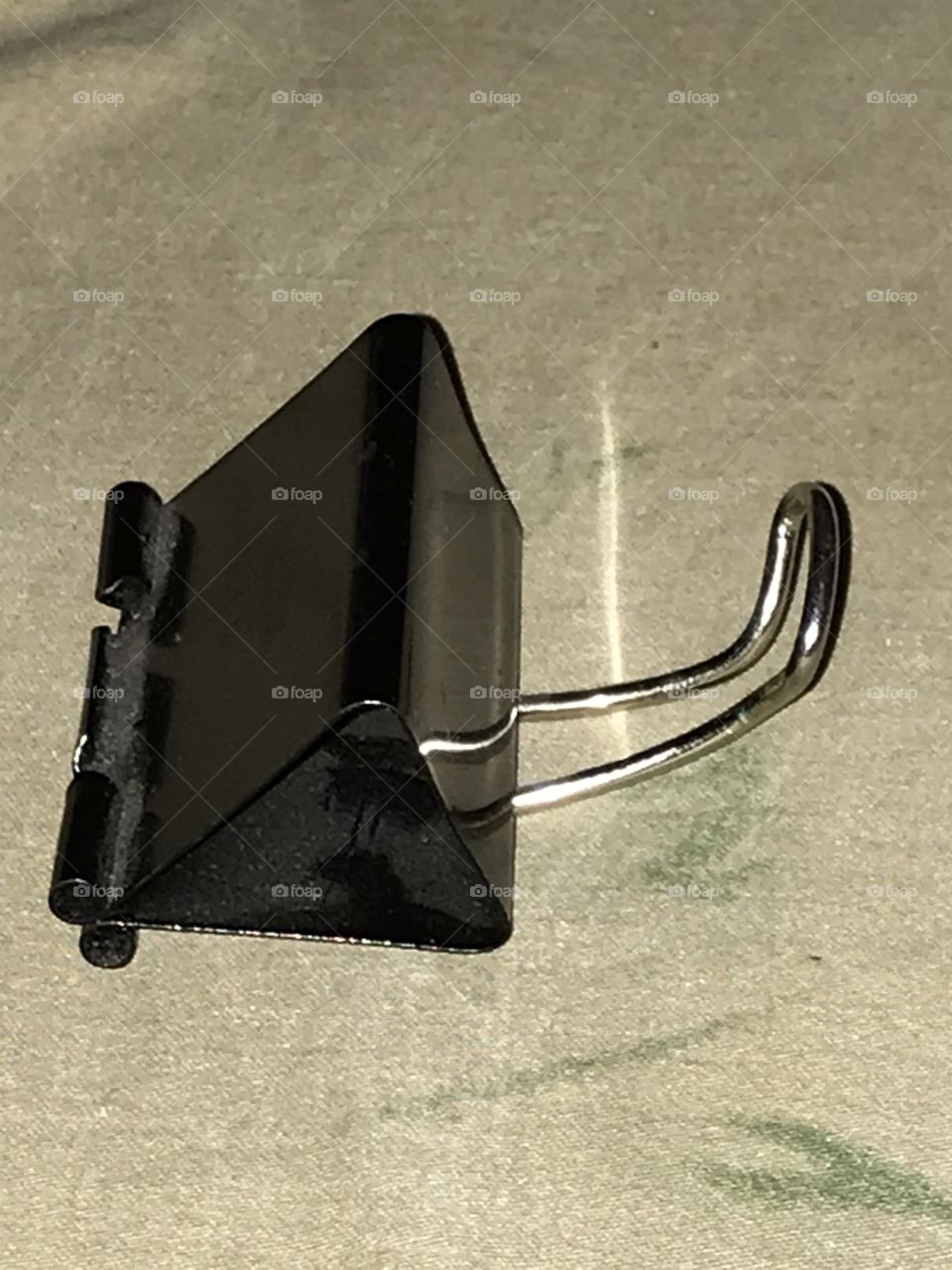 A smartphone stand made from a binder clip. It does a good job of holding up a wireless device.