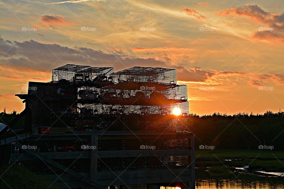 Sunrise and sunsets of USA - sunset reflection through a fisherman’s lobster traps and magnificent golden sky