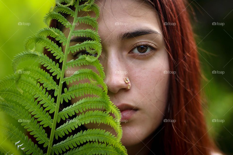 Young woman with fern leaf