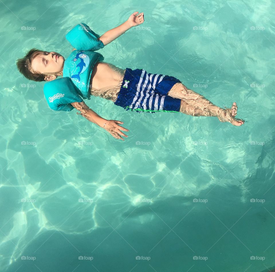 Boy with armbands in swimming pool