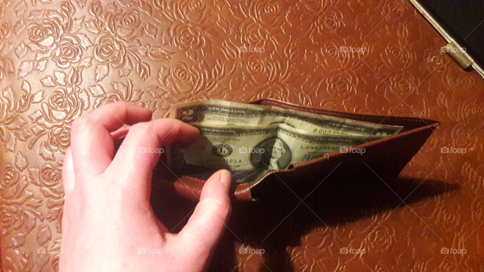 A $2 bill inside of a leather wallet