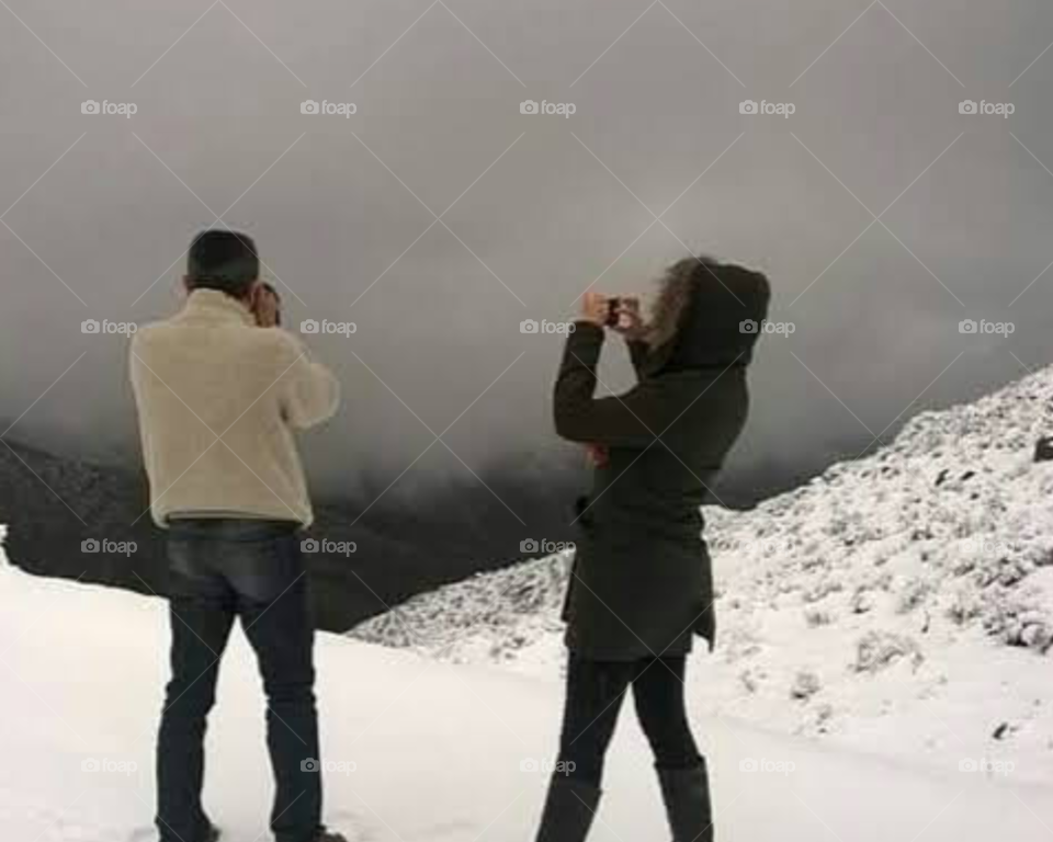 two people photographing the snow