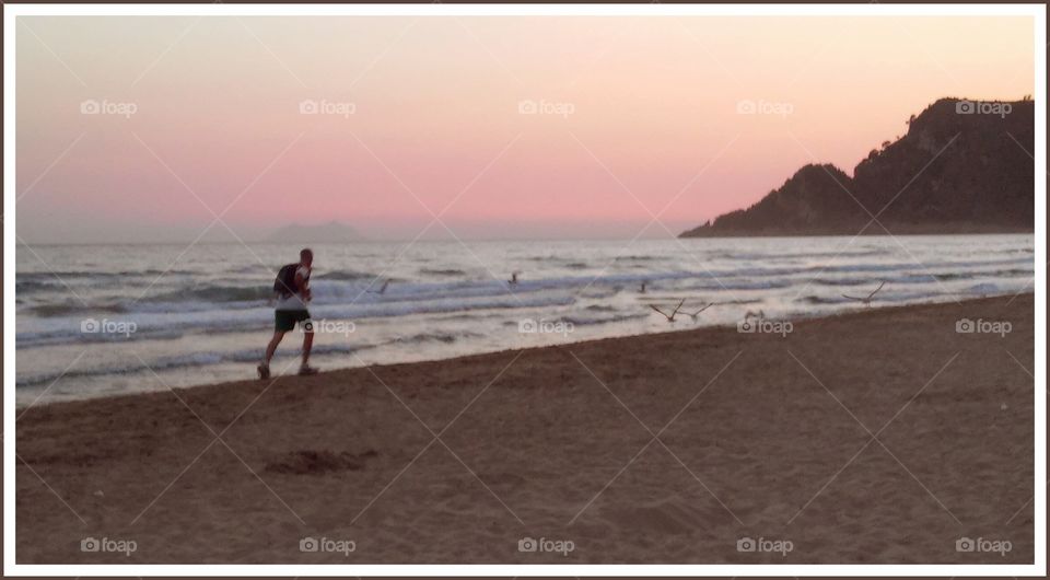 Running. I saw this guy running with a heavy bag and a lot of fatigue, on the beach in the evening.The seagulls seem very scared!
