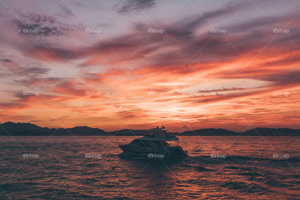 A lonely ship sailing under the amazing sunset sky