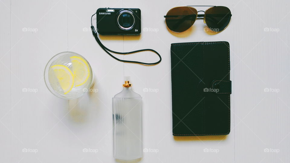 notebook, glasses, camera, toilet water and lemonade on a white background