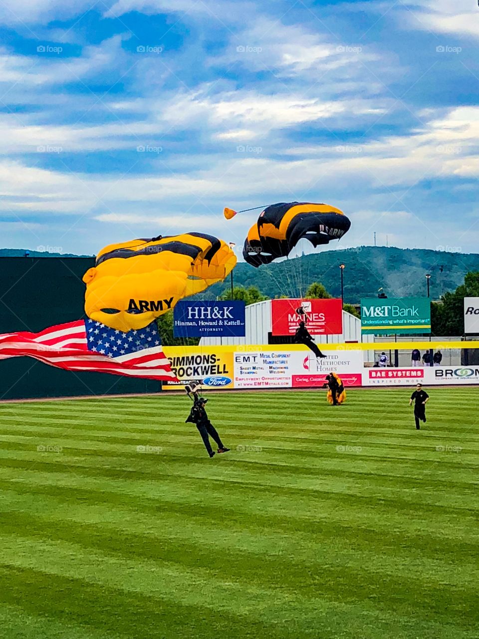 Army skydivers during national anthem at a baseball game 