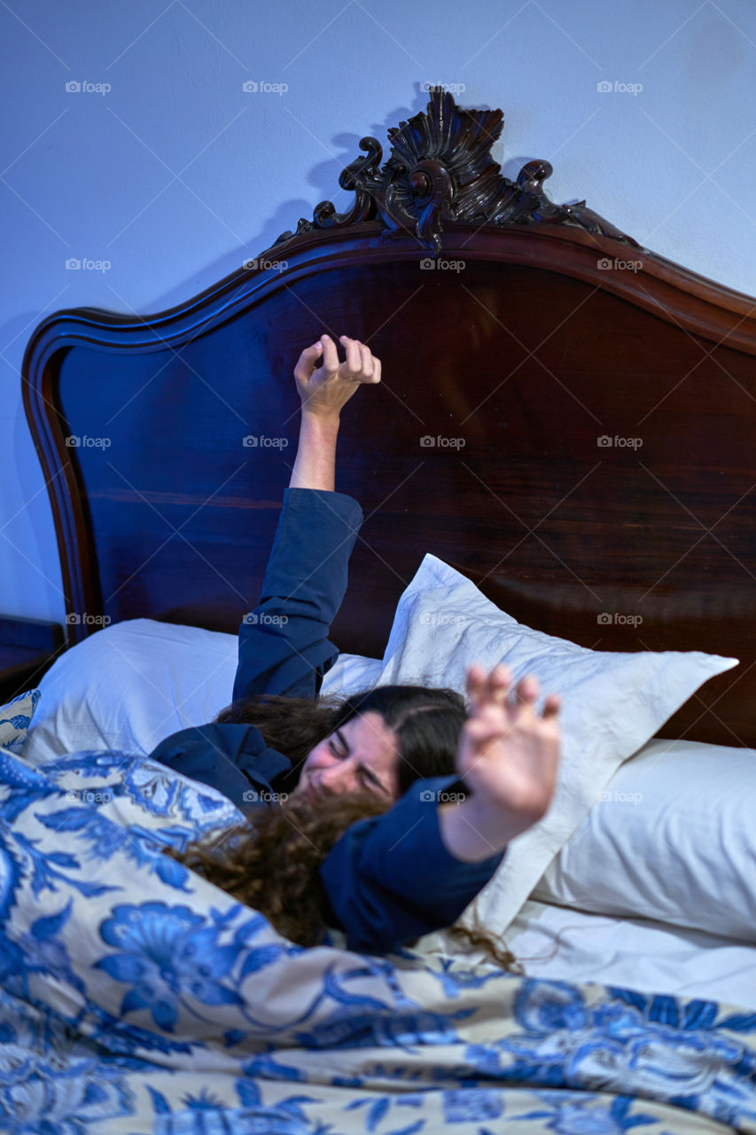 Young woman stretching on bed