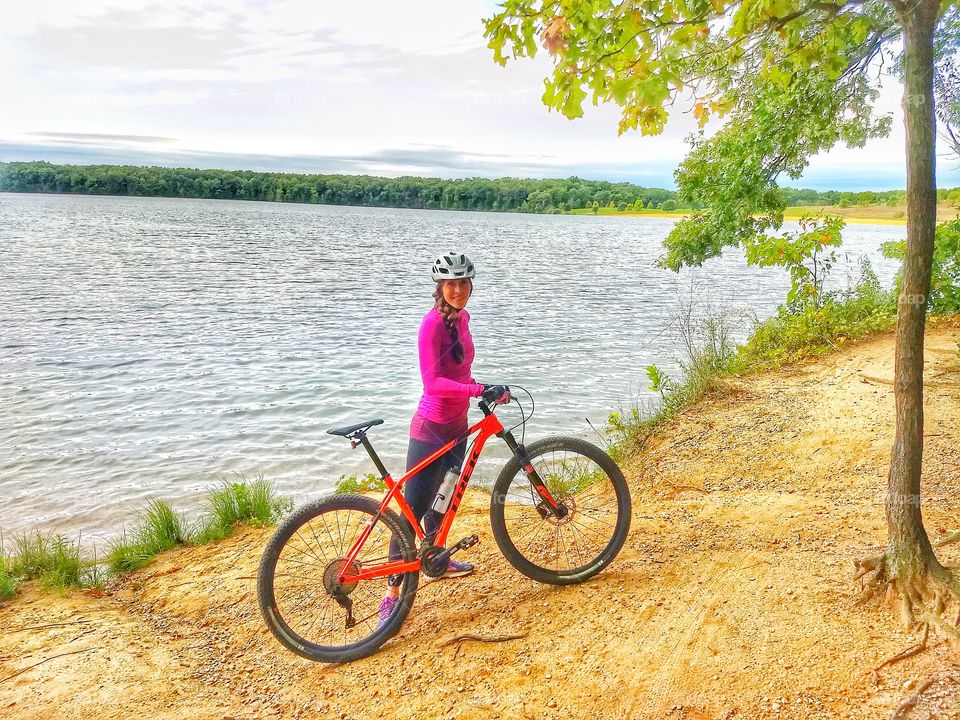 sexy cyclist poses by lake