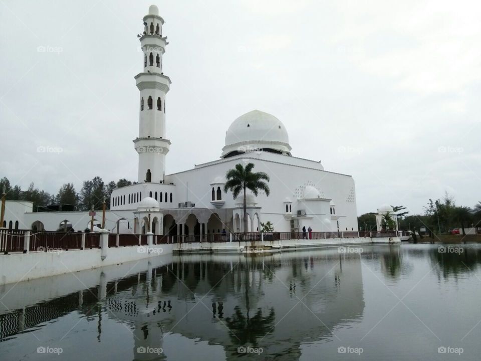 White floating mosque at terengganu malaysia..reflection on lake visible by necromacy